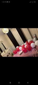 a bunch of red and white balloons on a bed at اوليفيا للشقق الفندقية in Amman