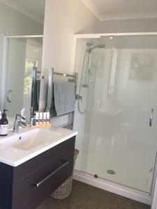 a bathroom with a sink and a shower at Kaimai Range Country Getaway in Katikati