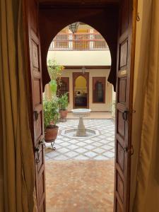 an open door to a courtyard with a fountain at Riad Amalia in Marrakech