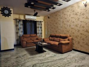 uma sala de estar com dois sofás de couro e uma mesa em Fully Airconditioned Uber Luxurious Holiday Home. em Kundapur