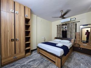 um quarto com uma cama, um closet e um espelho em Fully Airconditioned Uber Luxurious Holiday Home. em Kundapur