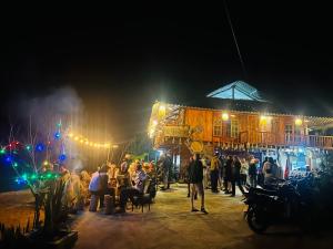 a crowd of people standing outside of a building at night at Du Gia Field View Homestay in Làng Cac
