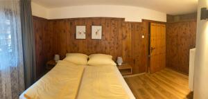 a large bed in a room with wooden walls at Ferienwohnung Gams in Finkenberg