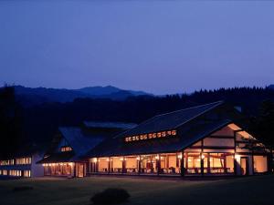 a large building with lights on at night at Towada Prince Hotel in Kosaka