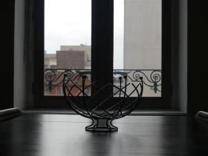 un vase assis sur une table devant une fenêtre dans l'établissement Bel Appart' Confort VILLEURBANNE TRAM T3 WIFI, à Villeurbanne