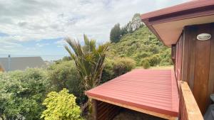 a wooden deck with a mountain in the background at Pohara's Kauri Lodge in Pohara