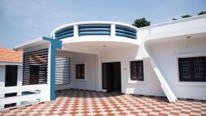 a large white house with a balcony on top at Sai Residency ECR in Chennai