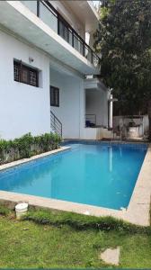 a large blue swimming pool in front of a house at Sai Residency ECR in Chennai