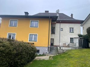 żółty dom ze schodami na dziedzińcu w obiekcie Wohnen im ehemaligen Kloster in Schörfling am Attersee w mieście Schörfling