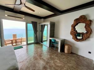 a living room with a mirror and a table at Ocean Front Apartments in Koh Tao
