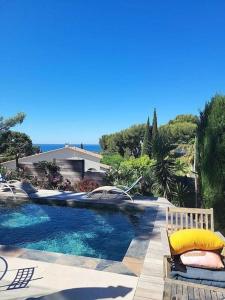 uma piscina com um banco ao lado de uma casa em T3 luxe vue mer em Cassis
