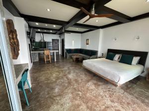 a bedroom with a bed and a living room at Ocean Front Apartments in Koh Tao