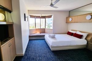 um quarto de hotel com uma cama e uma janela em Tiki Hotel Apartments Surfers Paradise em Gold Coast