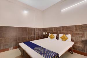 a bedroom with a large bed with wooden walls at SPOT ON Ganga Yatri Nivas in Gundlupet