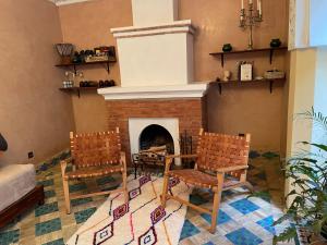 a living room with two chairs and a fireplace at Riad Amalia in Marrakech