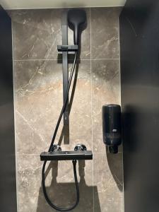 a hair dryer and a soap dispenser on a wall at Den Röda Båten in Stockholm