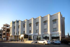 un bâtiment blanc avec des voitures garées devant lui dans l'établissement The Glorious Hotel, à Médine