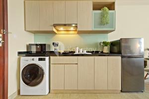 een keuken met een vaatwasser en een wasmachine bij Nyansa by Kozystay - Menteng in Jakarta