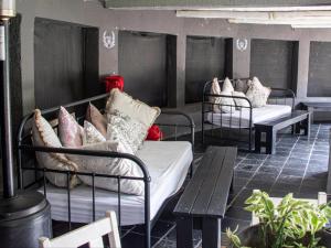 a row of beds and a bench on a patio at Muckleneuk Manor in Pretoria