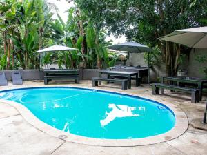 una piscina con mesas de picnic y sombrillas en Muckleneuk Manor, en Pretoria 22 fotos más