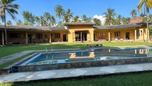 dom z basenem przed nim w obiekcie Rivendell Twisted Tree w mieście Kurunegala