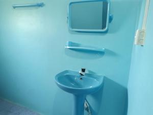 een blauwe badkamer met een wastafel en een spiegel bij Vijay Thulasi Beach View in Nilaveli