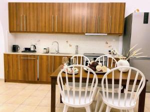 斯佩察島的住宿－Villa Jenny Stylianou，厨房配有桌子、四把椅子和冰箱