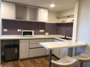 a kitchen with white cabinets and a white counter top at Rajhans belliza 2bhk Flats in Surat