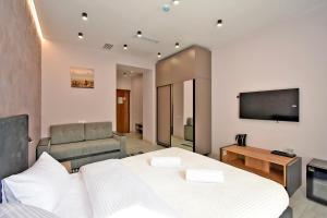 a bedroom with a bed and a flat screen tv at Avenue 23 Boutique Hotel in Yerevan