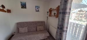 un salon avec un canapé et une fenêtre dans l'établissement Bernex T2 toute saison au pied des pistes, à Bernex