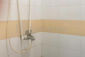 a shower with a hose in a bathroom at Hannie House RedPartner near Jalan Ahmad Yani Banjarmasin in Sungai Lutus