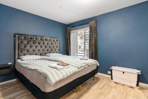 1 dormitorio con paredes azules y 1 cama grande en Arctic Suite - 5 minutes from city centre, en Tromsø