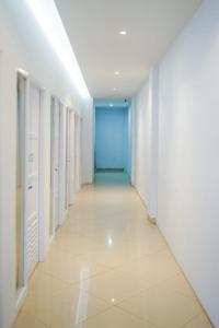 an empty hallway with white walls and a blue door at Kareem Syariah Hostel Bukittinggi in Bukittinggi