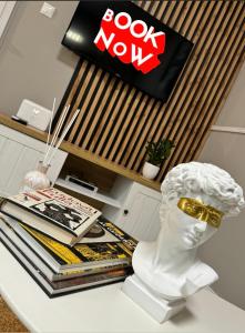 a white statue sitting on a table with books at Svatého Pasáž BOUTIQUE Apartments with free parking in Trnava