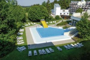 - une vue sur la piscine et ses chaises longues dans l'établissement Ferienapartment TESLA im Wellnesshotel - Bayerischer Wald, à Sankt Englmar