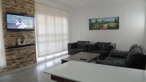 a living room with two chairs and a flat screen tv at CommonLens Inn in Entebbe