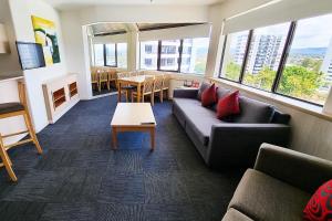 a living room with a couch and a table at Tiki Hotel Apartments Surfers Paradise in Gold Coast