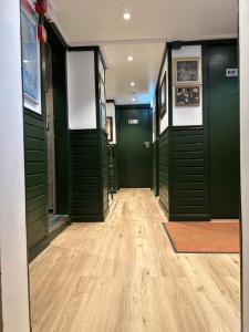 a hallway with green doors and a wooden floor at Den Röda Båten in Stockholm