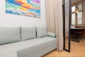 a couch in a living room with a painting on the wall at Apartament Nad Motławą Seredyńskiego by Renters in Gdańsk