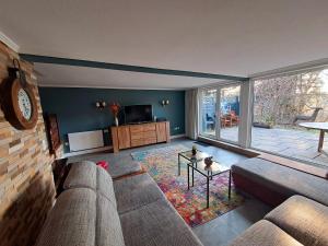 uma sala de estar com um sofá e uma televisão em Villa SKYLO em Winterberg