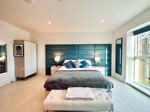 um quarto com uma cama grande e uma cabeceira azul em 34 Cliff Edge 2nd floor Newquay luxury sea-view residence em Newquay