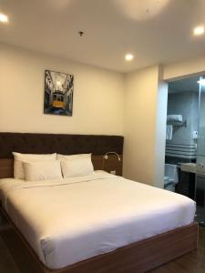 een slaapkamer met een wit bed met een treinfoto aan de muur bij Khách sạn QUEENIE in Hai Phong