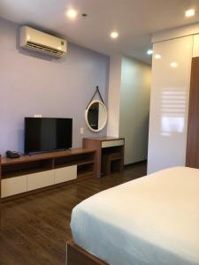 a bedroom with a bed and a tv and a mirror at Khách sạn QUEENIE in Hai Phong