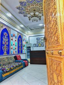 Habitación con cama y lámpara de araña. en Jahangir Boutique Bukhara, en Bukhara