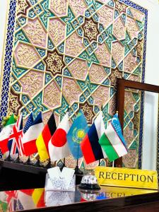 a room with a wall with different flags on a shelf at Jahangir Boutique Bukhara in Bukhara