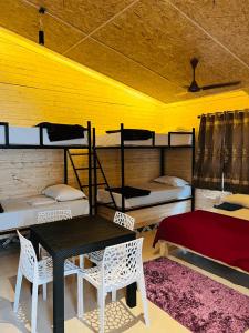 a room with a table and chairs and bunk beds at Kodai Elegance in Kodaikānāl