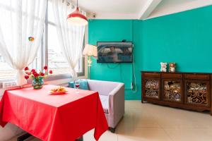 a living room with a red table and a couch and a tv at Changsha Fuxiangyuan International Hostel in Changsha
