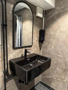 a bathroom with a black sink and a mirror at Den Röda Båten in Stockholm