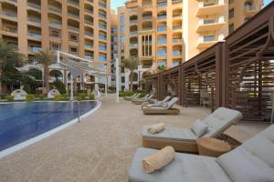 un patio del resort con sedie a sdraio e piscina di Town house residency 4 a Doha