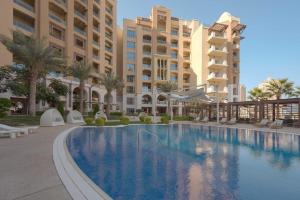 una piscina di fronte ad alcuni edifici di Town house residency 4 a Doha